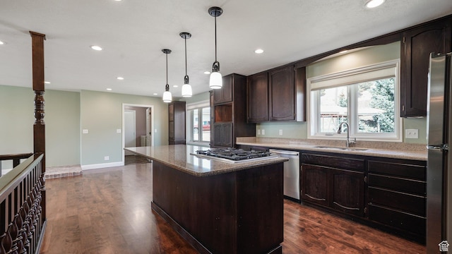 kitchen with dark wood-style floors, dark brown cabinets, a kitchen island, stainless steel appliances, and a sink