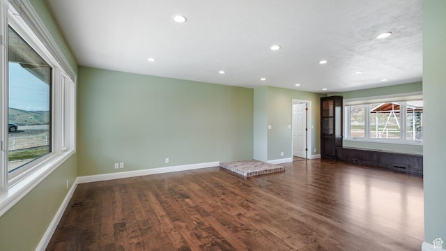 spare room with baseboards, recessed lighting, and wood finished floors