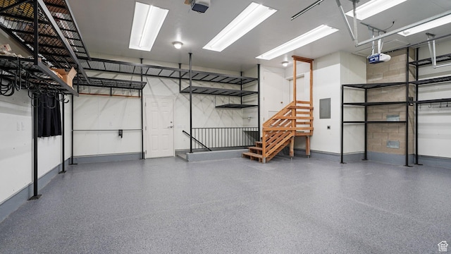 garage featuring electric panel, baseboards, and a garage door opener