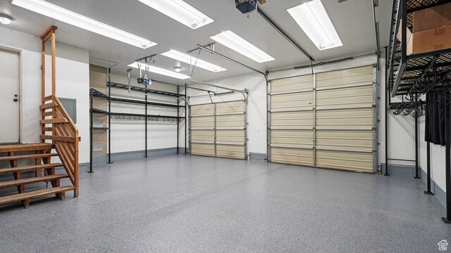 garage with baseboards and a garage door opener