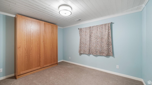 unfurnished bedroom with visible vents, baseboards, crown molding, and carpet floors