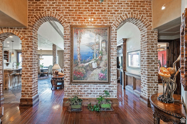 13879 S Standing Oak Dr E, Draper, UT 84020 - hallway featuring arched walkways, wood-type flooring, a towering ceiling, and ornate columns