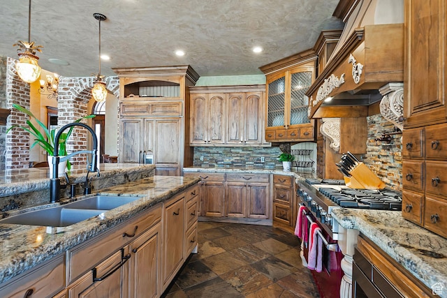 13879 S Standing Oak Dr E, Draper, UT 84020 - kitchen featuring pendant lighting, high end stove, stone finish flooring, a sink, and decorative backsplash
