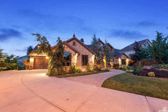 13879 S Standing Oak Dr E, Draper, UT 84020 - french provincial home with concrete driveway, a chimney, stone siding, a front yard, and brick siding