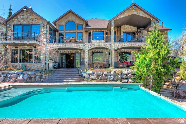 13879 S Standing Oak Dr E, Draper, UT 84020 - back of house featuring an outdoor pool, a patio area, and a balcony