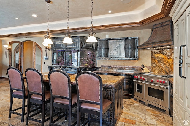 13879 S Standing Oak Dr E, Draper, UT 84020 - kitchen with a raised ceiling, arched walkways, premium range hood, double oven range, and stone tile floors