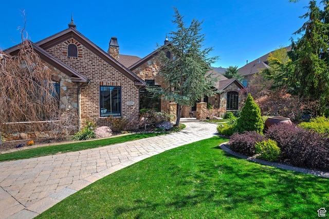13879 S Standing Oak Dr E, Draper, UT 84020 - view of front facade featuring a chimney, a front yard, stone siding, and brick siding