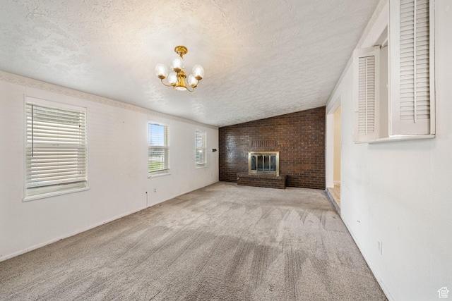 unfurnished living room with a fireplace, carpet, a notable chandelier, and a textured ceiling