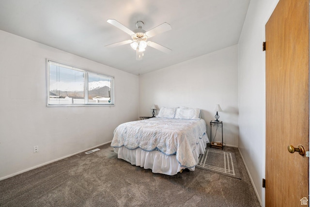 carpeted bedroom with visible vents, baseboards, and a ceiling fan
