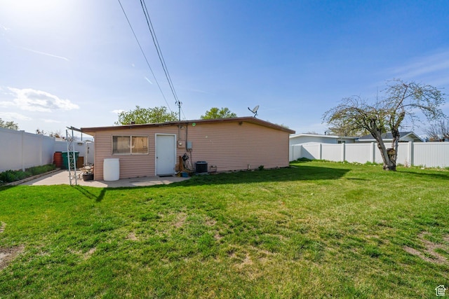 back of house featuring central AC, a fenced backyard, a patio, and a lawn