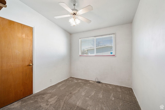 carpeted empty room with a ceiling fan and vaulted ceiling