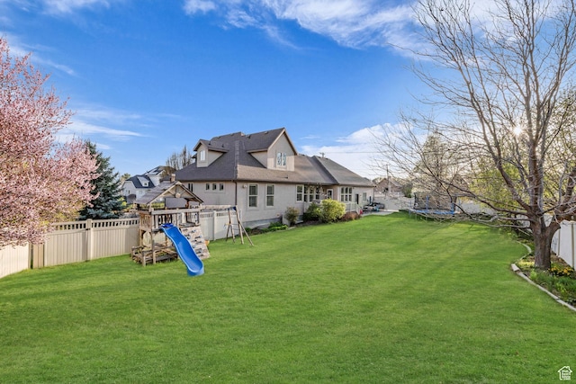 888 W 2800 N, Pleasant Grove, UT 84062 - back of house featuring a trampoline, a fenced backyard, a playground, and a lawn