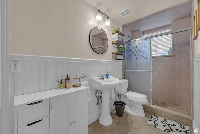 888 W 2800 N, Pleasant Grove, UT 84062 - full bathroom featuring a shower stall, tile patterned flooring, visible vents, a wainscoted wall, and toilet