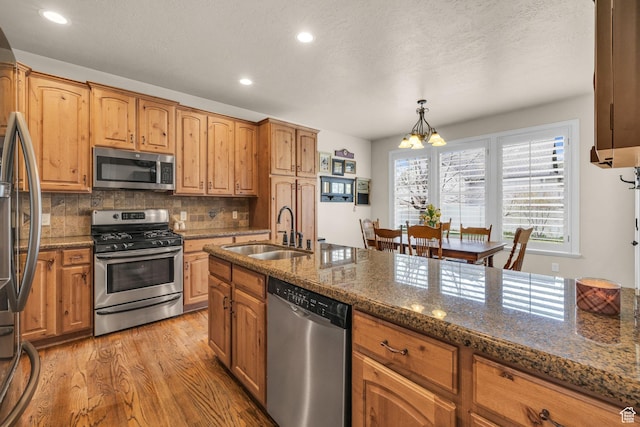 888 W 2800 N, Pleasant Grove, UT 84062 - kitchen with a sink, a chandelier, light wood finished floors, stainless steel appliances, and backsplash