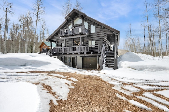 4100 Buck Way Unit 1947, Heber City, UT 84032 - snow covered house featuring an attached garage, log siding, a balcony, and stairway