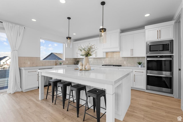 3248 S Forest Ave, Saratoga Springs, UT 84045 - kitchen with custom exhaust hood, appliances with stainless steel finishes, light countertops, and white cabinetry