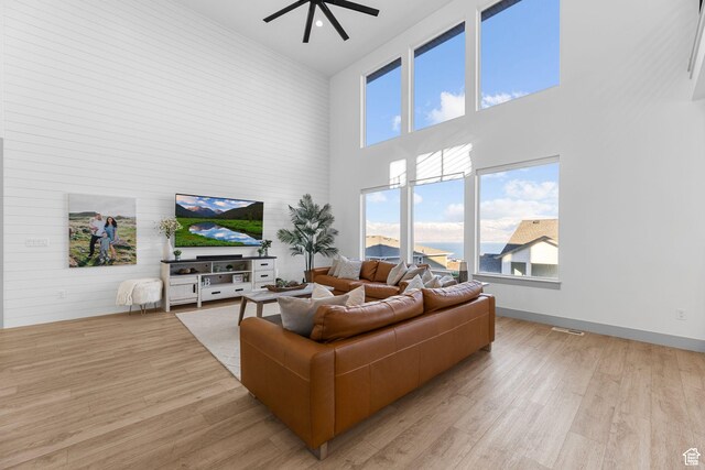 3248 S Forest Ave, Saratoga Springs, UT 84045 - living area with visible vents, ceiling fan, light wood finished floors, and a towering ceiling