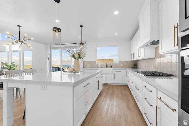 3248 S Forest Ave, Saratoga Springs, UT 84045 - kitchen featuring plenty of natural light, light wood finished floors, a notable chandelier, and a kitchen island