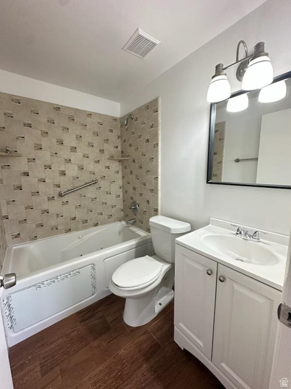bathroom with visible vents, washtub / shower combination, toilet, vanity, and wood finished floors