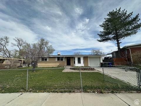 view of front of home featuring a front yard, an attached garage, driveway, and a fenced front yard