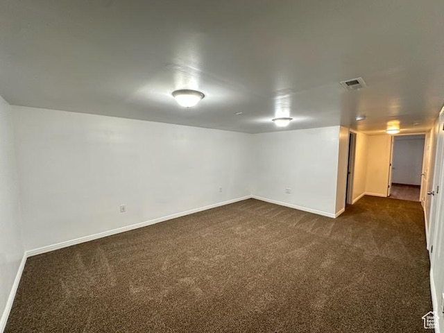 finished basement featuring visible vents, baseboards, and dark colored carpet