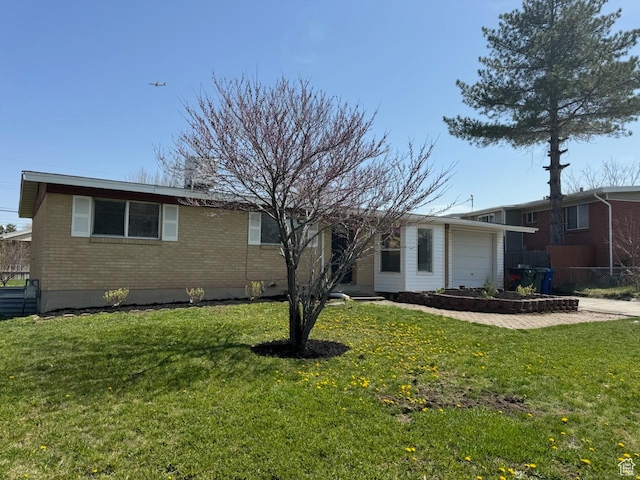 ranch-style home with an attached garage, a chimney, a front lawn, and brick siding