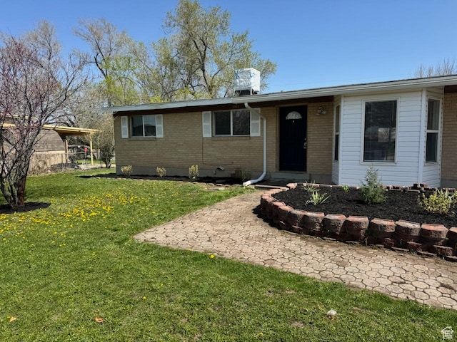 ranch-style home with a front yard and brick siding
