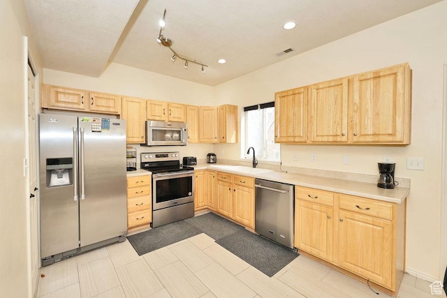 kitchen with light countertops, visible vents, appliances with stainless steel finishes, a sink, and light brown cabinetry