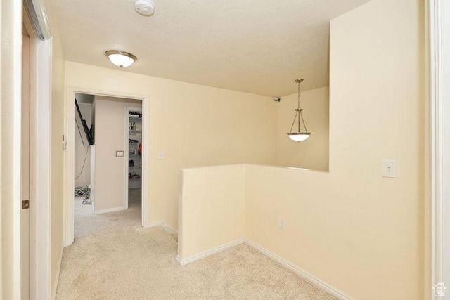 interior space with baseboards and light colored carpet