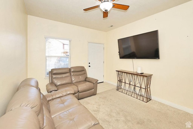 carpeted living area featuring ceiling fan and baseboards