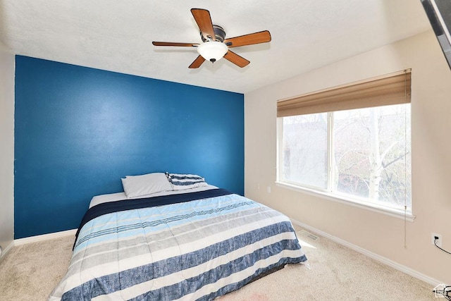carpeted bedroom featuring baseboards and ceiling fan