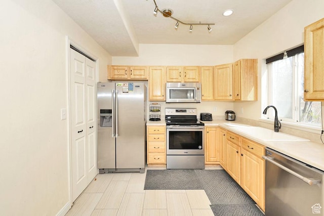 kitchen with a sink, light countertops, light brown cabinetry, and stainless steel appliances