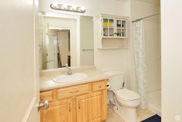 full bathroom with tile patterned floors, curtained shower, vanity, and toilet