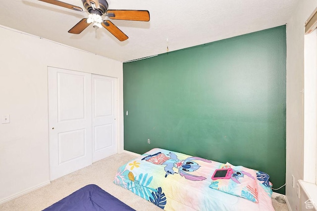 bedroom featuring a closet, ceiling fan, baseboards, and carpet floors