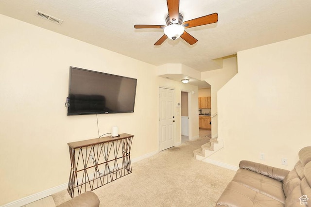 unfurnished living room with light colored carpet, ceiling fan, baseboards, and visible vents