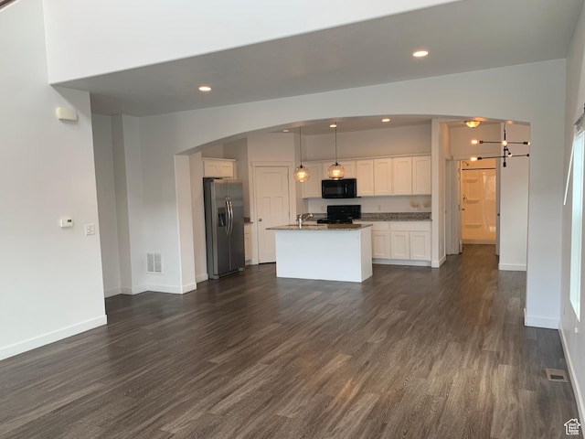 kitchen with dark wood-style floors, white cabinetry, stainless steel fridge, and black microwave