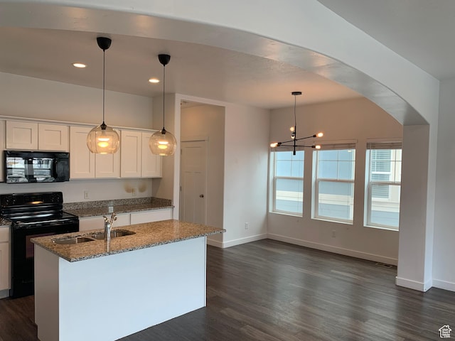 kitchen featuring stone countertops, dark wood-style floors, a sink, and black appliances