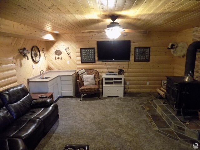 475 W 100 N, Aurora, UT 84620 - living room featuring a wood stove, rustic walls, dark carpet, wooden ceiling, and a ceiling fan