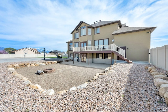 back of property with a patio, stucco siding, stairway, a wooden deck, and fence