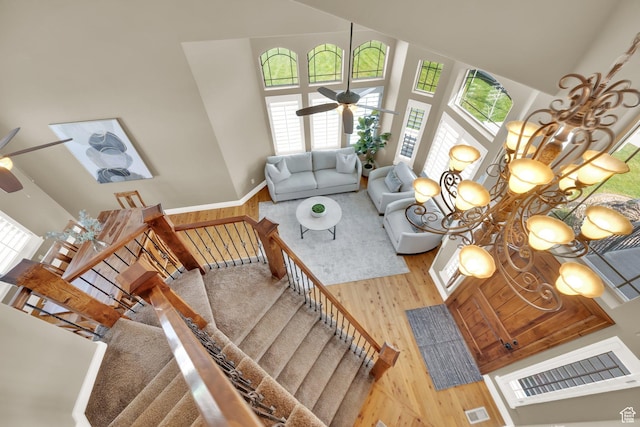 living area featuring plenty of natural light, a high ceiling, wood finished floors, and ceiling fan