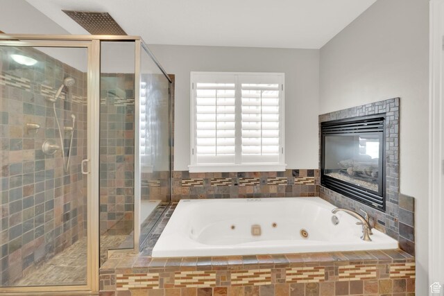 full bath featuring a jetted tub, a stall shower, and a healthy amount of sunlight