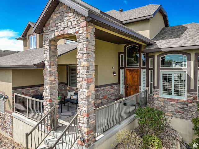 exterior space with roof with shingles, stucco siding, and stone siding