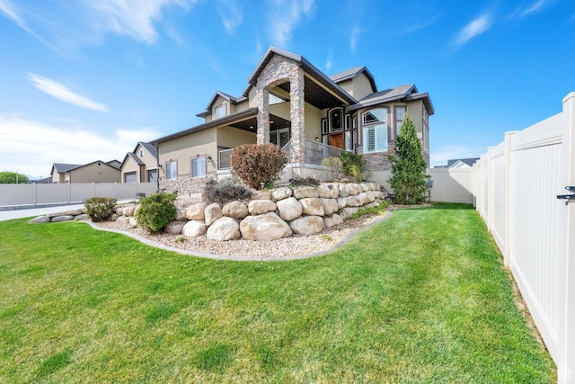 view of property exterior with a fenced backyard, stucco siding, stone siding, and a lawn