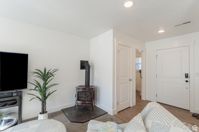 3048 S 400 W, Nibley, UT 84321 - living room with wood finished floors, a wood stove, baseboards, and visible vents
