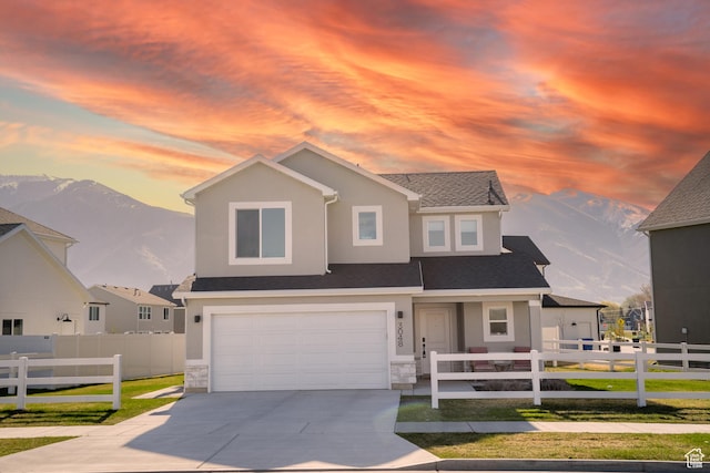 view of front of house with an attached garage, driveway, fence, and stucco siding