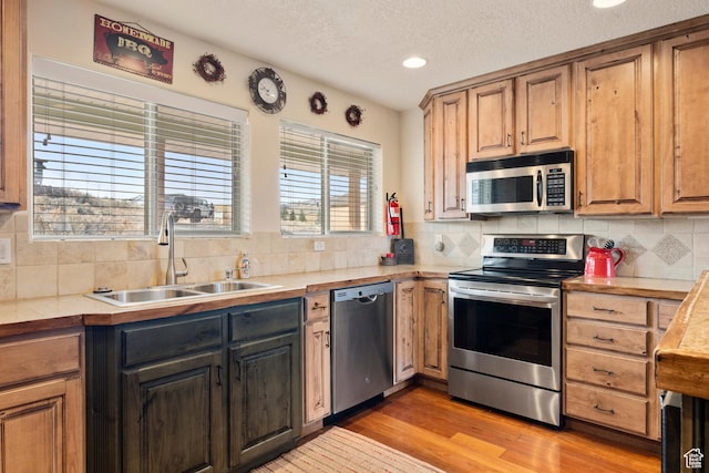 17 Wedge Way, Garden City, UT 84028 - kitchen featuring appliances with stainless steel finishes, a sink, decorative backsplash, light countertops, and a textured ceiling