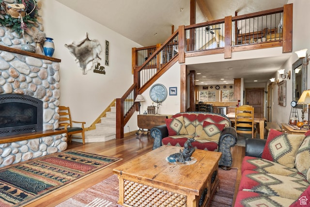 17 Wedge Way, Garden City, UT 84028 - living room featuring wood finished floors, stairway, a stone fireplace, high vaulted ceiling, and baseboards