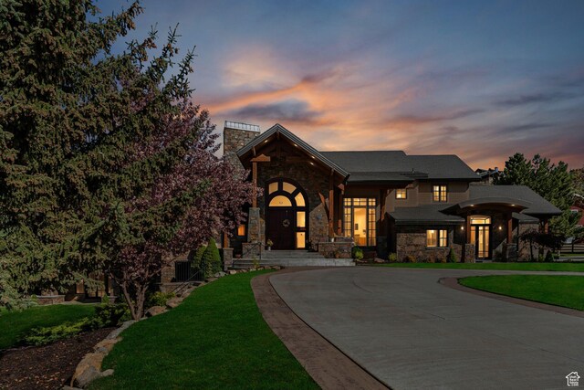 2499 River Meadows Ln, Midway, UT 84049 - view of front facade featuring stone siding, curved driveway, a chimney, and a front lawn