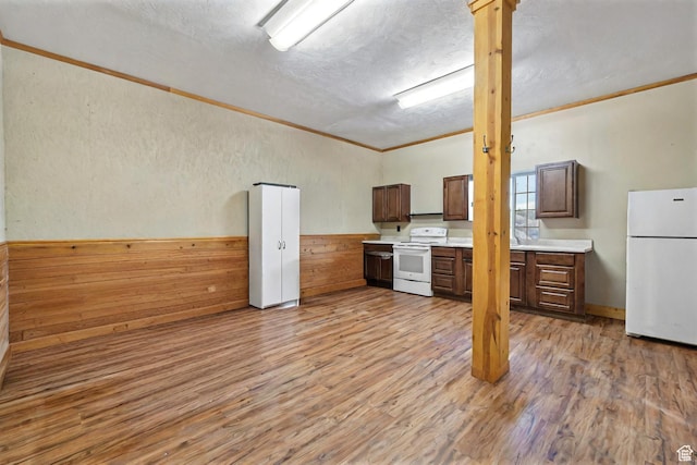2499 River Meadows Ln, Midway, UT 84049 - kitchen featuring white appliances, crown molding, light countertops, light wood finished floors, and wood walls