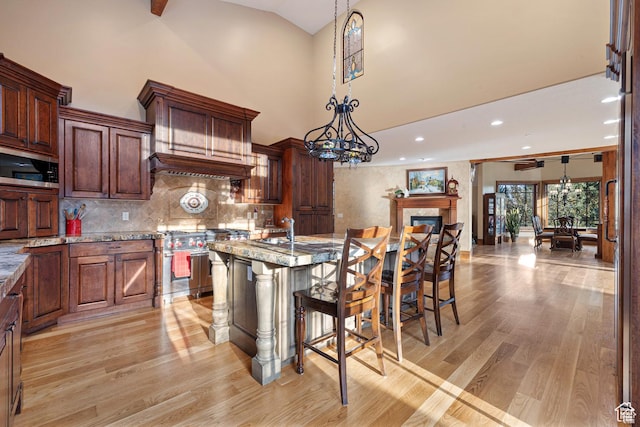 2499 River Meadows Ln, Midway, UT 84049 - kitchen featuring appliances with stainless steel finishes, high vaulted ceiling, light wood finished floors, pendant lighting, and a kitchen bar